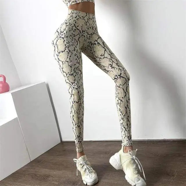 Un legging à motif peau de serpent associé à des baskets blanches.