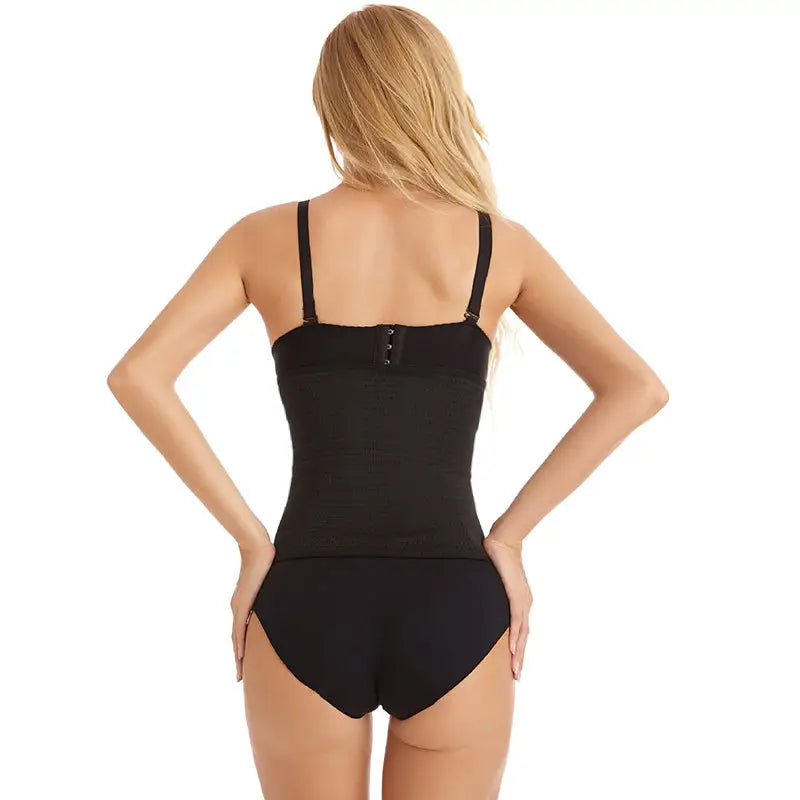 Maillot de bain une pièce noir porté par une femme blonde vue de dos.