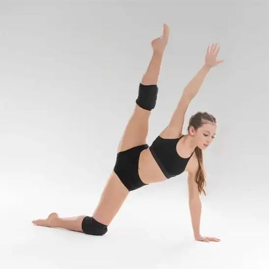 Danseuse effectuant une pose fendue en tenue de sport noire.