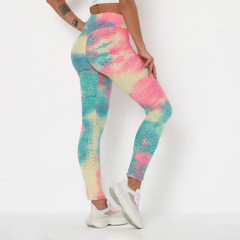 Des leggings teintés dans des couleurs pastel (rose, bleu et jaune) portés avec des baskets blanches.