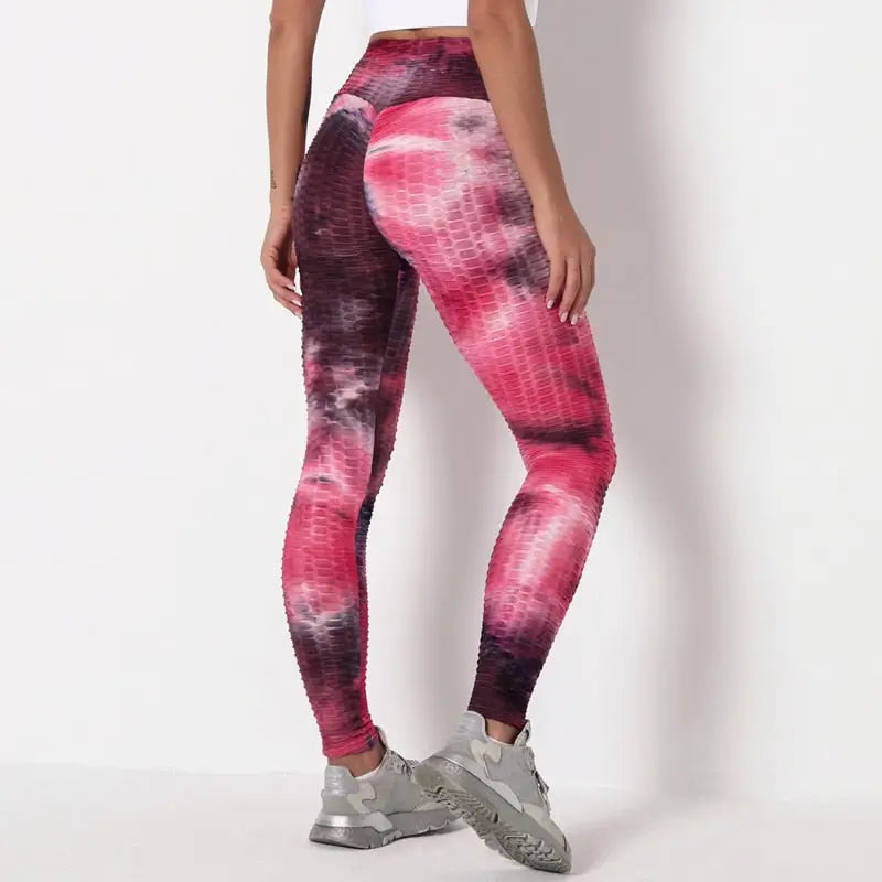 Leggings à motifs tie-dye dans les tons rose et bordeaux portés avec des baskets grises.